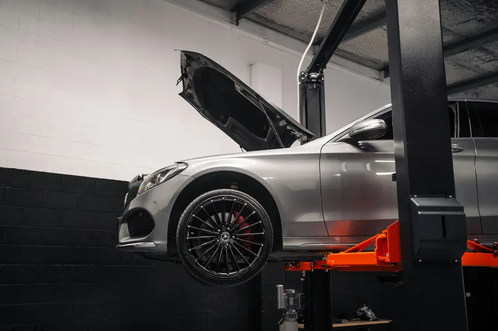 Car raised on a vehicle lift for MOT testing at Billingshurst MOT & Service Centre