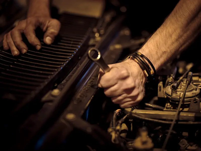 Mechanic tightening an engine component with a spanner in Billingshurst